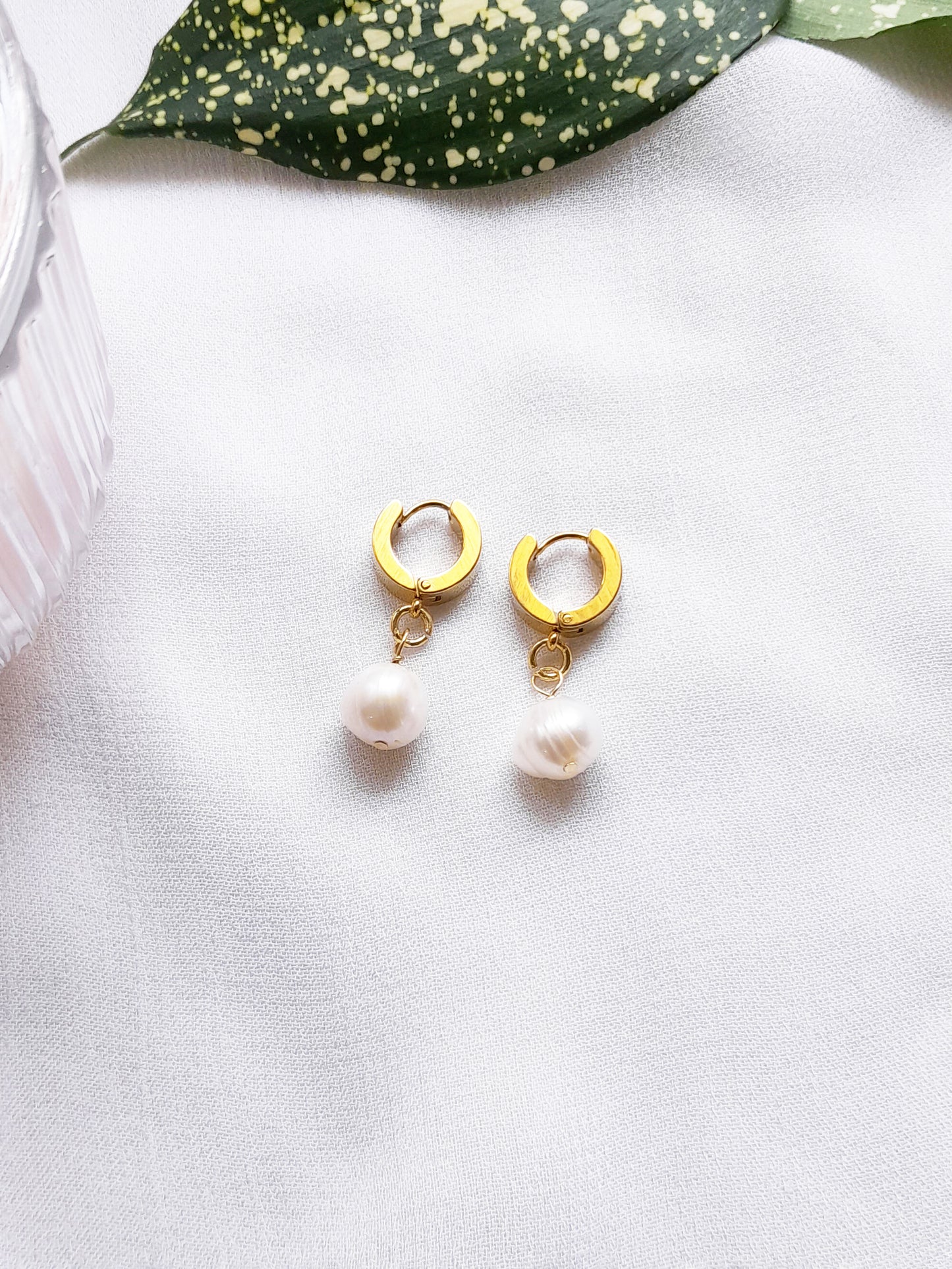 Thick gold hoop earrings with pearl charm