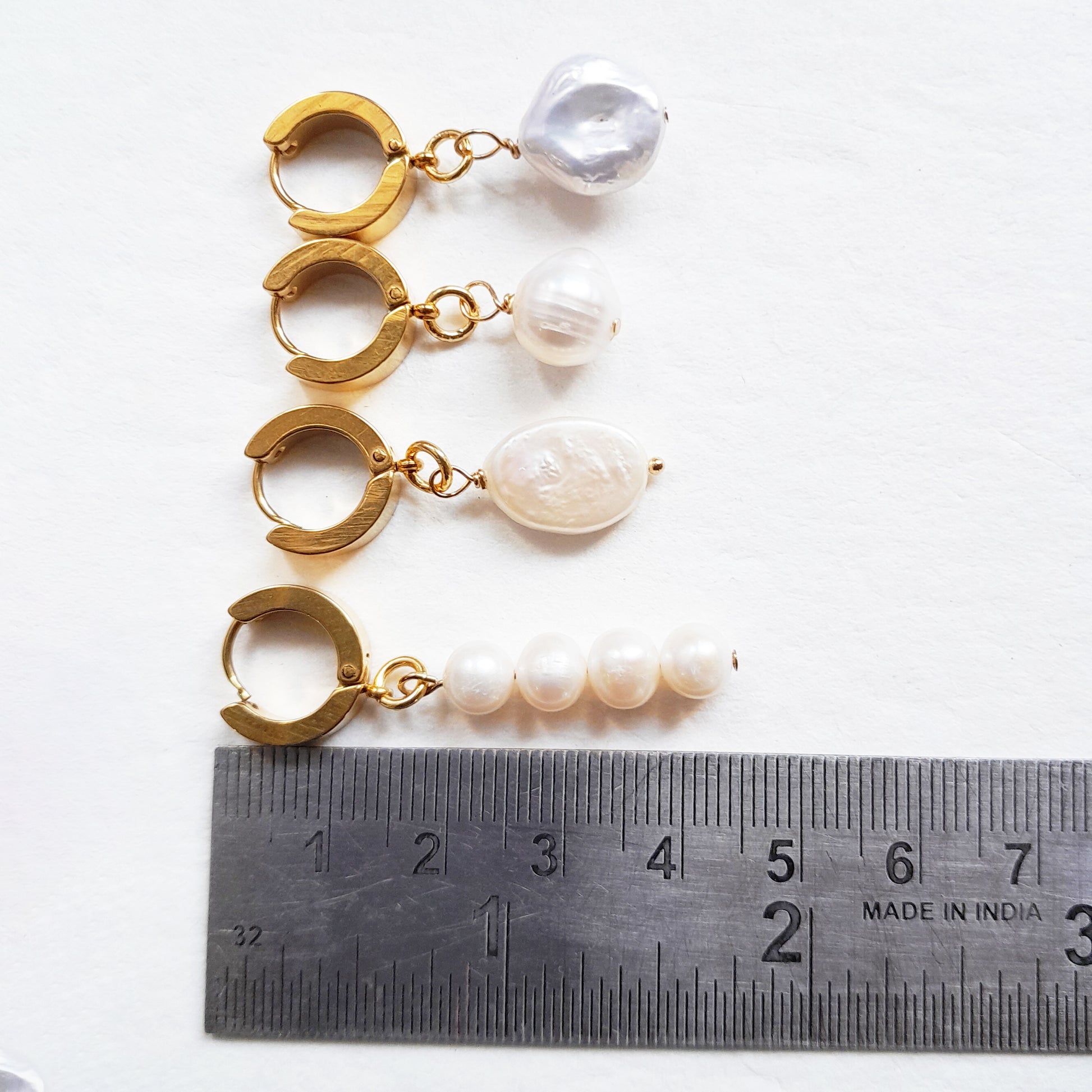 Thick gold hoop earrings with pearl charm